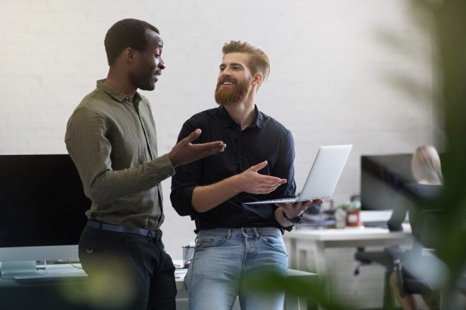 fpdl.in_dois-empresarios-alegres-discutindo-algo-no-laptop-e-sorrindo_171337-7308_large